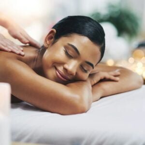 Shot of a relaxed an cheerful young woman getting a massage indoors at a spa